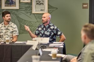 Two men sit at roundtable during a meeting